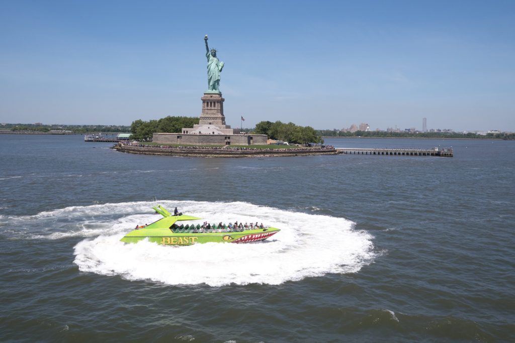 The Beast doing tricks and making splashes in front of the Statue of Liberty